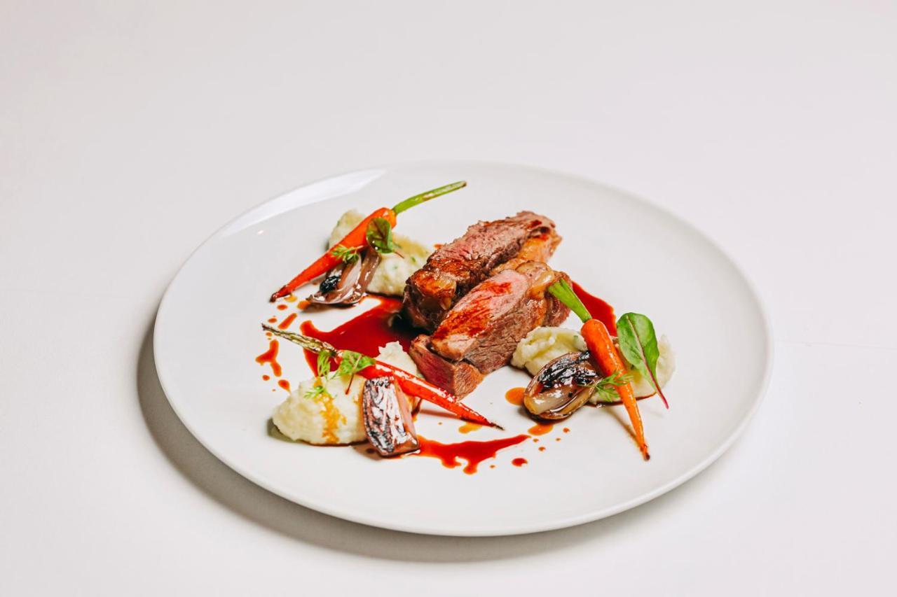 Ap Lago Montargil - Conference & Spa Dış mekan fotoğraf The photo features a beautifully plated dish. At the center, there are slices of a tender meat, likely beef, showcasing a juicy pink interior. Accompanying the meat are several elements: vibrant orange carrots, perhaps roasted or glazed, and dollops 